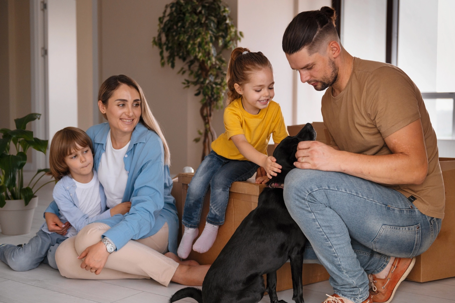 Happy family with two children and a dog in a new home.